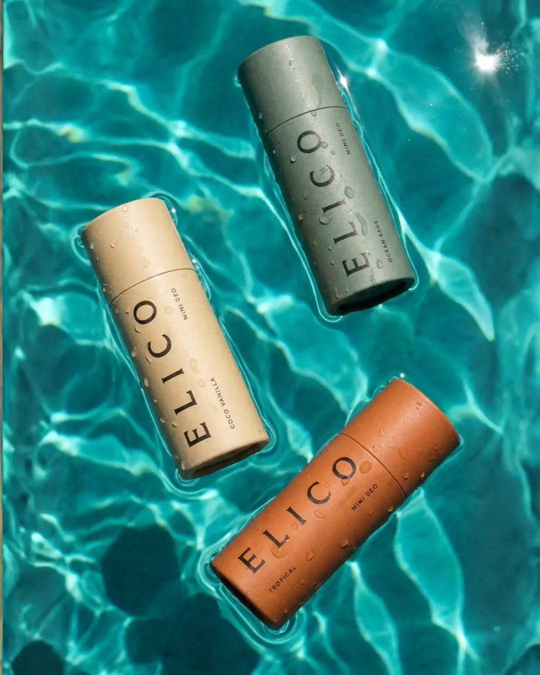 Three Mini Deo tubes floating in turquoise water
