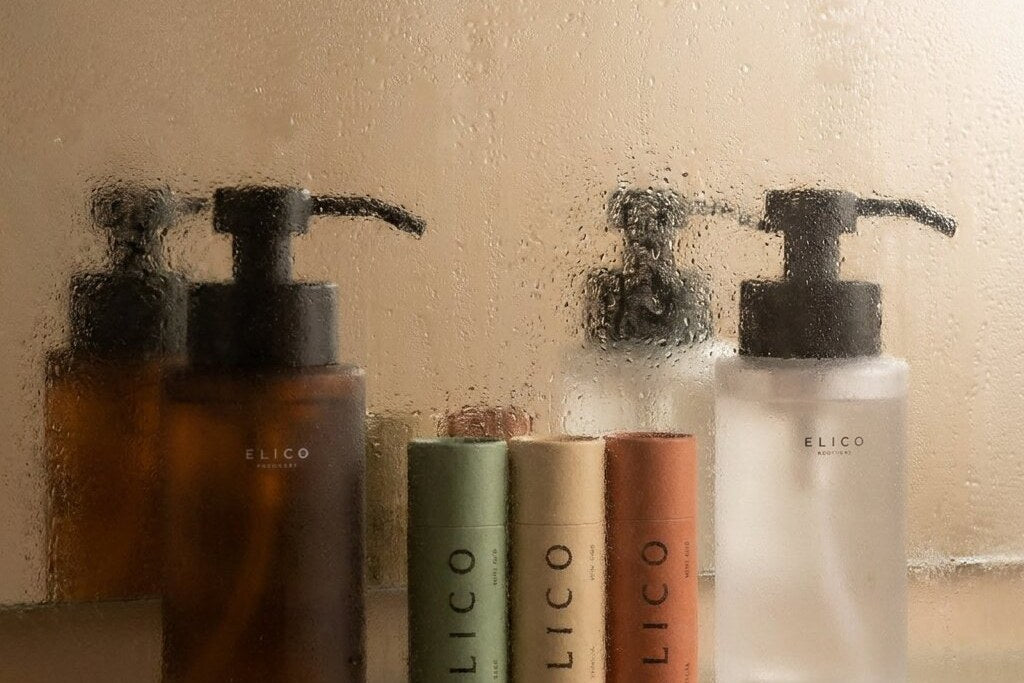 Amberkleurige en matglazen dispenser op een glazen plank in de badkamer