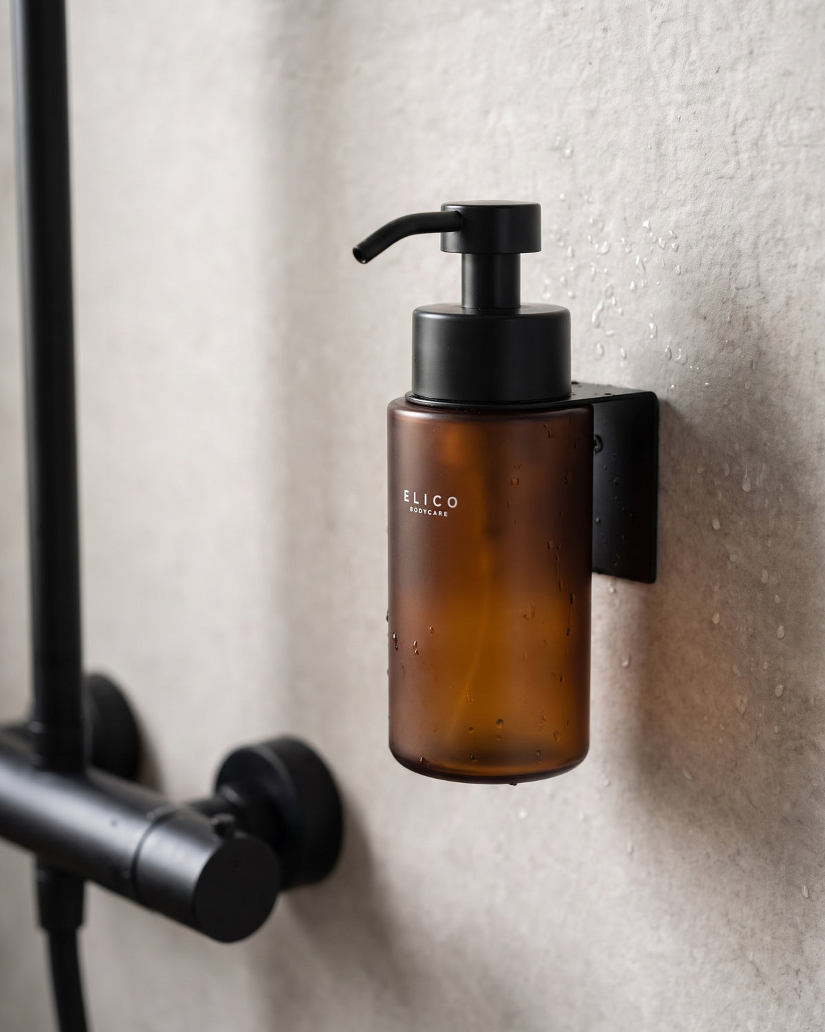 Amber Elico Bodycare dispenser in the matte black wall mount in the shower, next to a black mixer